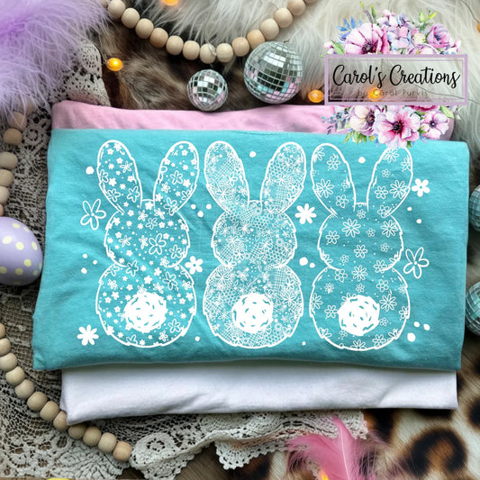 Turquoise t-shirt with white bunny designs on a decorative background