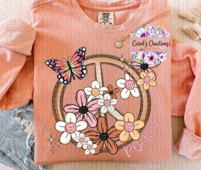 Pink t-shirt with peace symbol design featuring flowers and butterflies, branded 'Carol's Creations'.