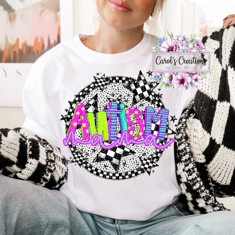 Person wearing a white sweatshirt with 'Autism Mama' design, sitting on a couch.