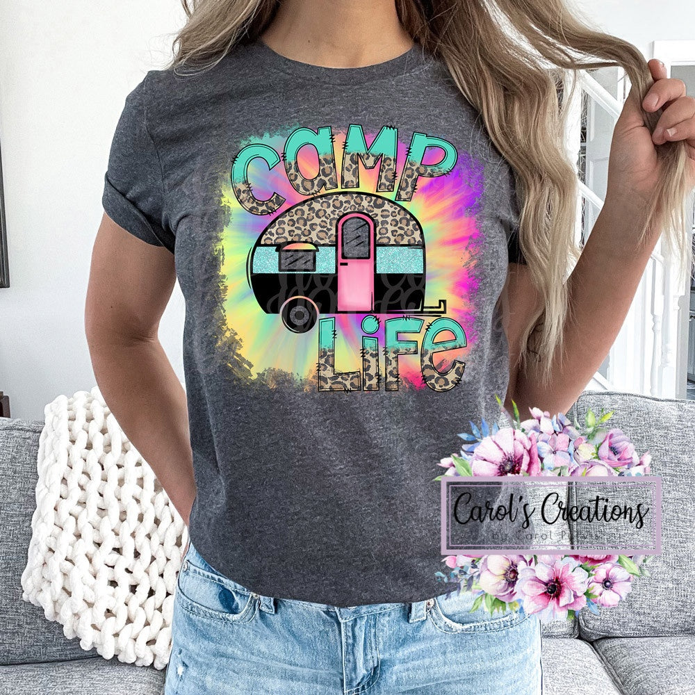 Person wearing a gray t-shirt with 'Camp Life' graphic design, featuring a colorful camper and leopard print elements.