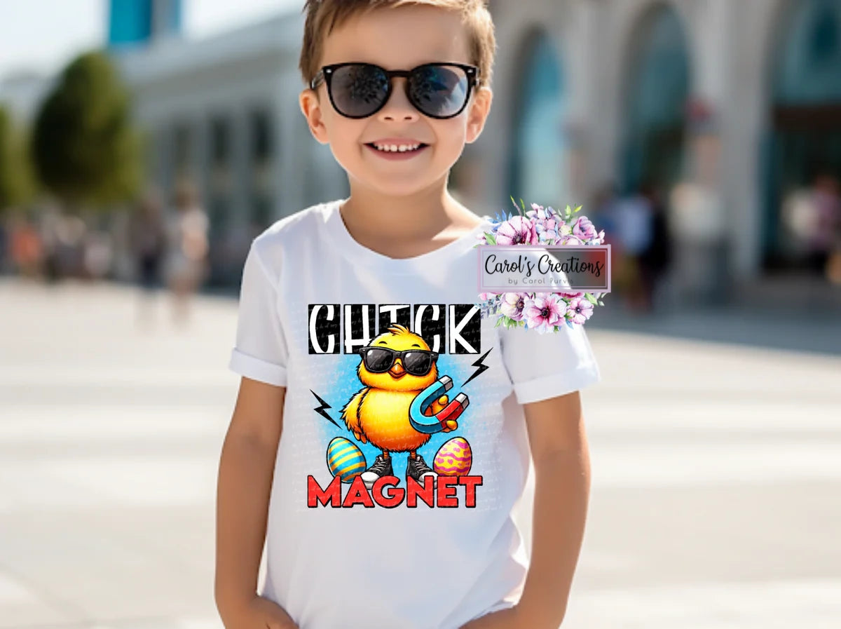 Child wearing a white t-shirt with a cartoon duck design and sunglasses, standing outdoors.