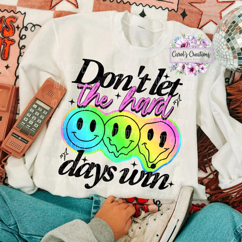White sweatshirt with rainbow smiley faces and text on a casual setting