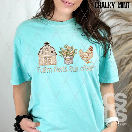 Person wearing a light blue t-shirt with farm-themed graphics and text.