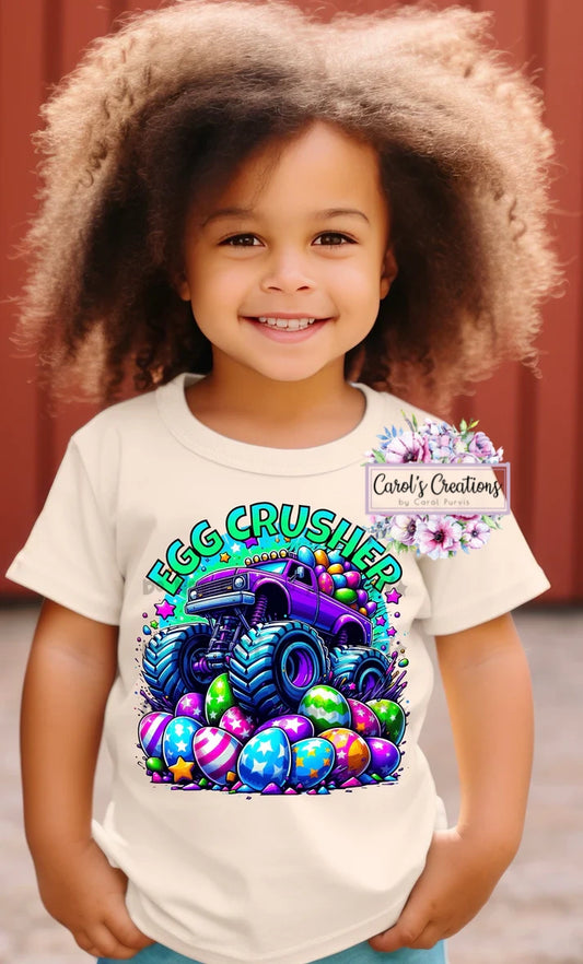 Child wearing a t-shirt with an 'Egg Crusher' graphic design featuring a colorful monster truck and Easter eggs.