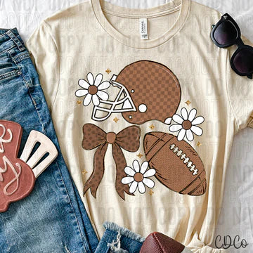 Beige t-shirt with football, helmet, and bow graphic design on a white background.