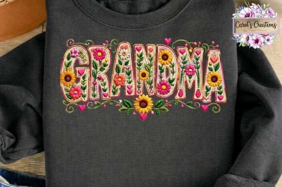 A dark charcoal gray long-sleeve t-shirt featuring a colorful embroidered-style graphic spelling 'GRANDMA' filled with sunflowers, hearts, and floral patterns. A 'Carol's Creations' brand watermark is visible in the top right corner.