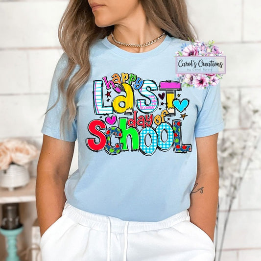 Person wearing a light blue t-shirt with 'Happy Last Day of School' text, standing against a white wall.