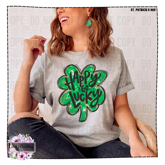 Person wearing a gray t-shirt with a green shamrock design and 'Happy Go Lucky' text, on a light background.