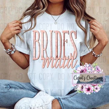 Person wearing a white t-shirt with 'BRIDES MATT' text, sitting on a wooden floor.