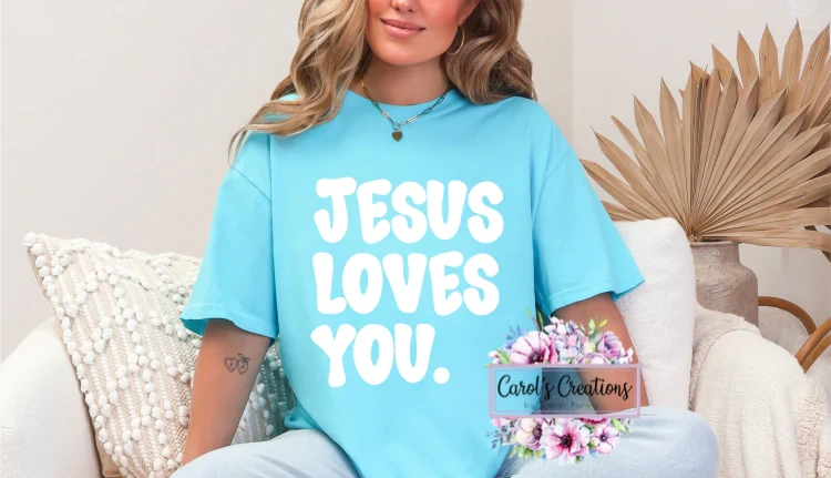 Person wearing a blue t-shirt with 'Jesus Loves You' text, sitting on a couch.