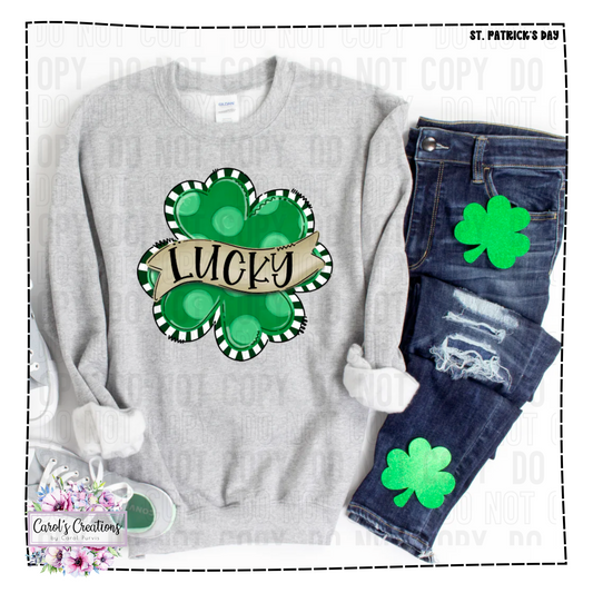 Gray sweatshirt with green shamrock design and 'Lucky' text, paired with jeans and a mug.