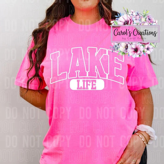 Person wearing a bright pink 'Lake Life' t-shirt with a brand logo in the corner.