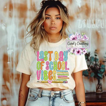 Person wearing a 'Last Day of School Vibes' t-shirt with floral decorations.
