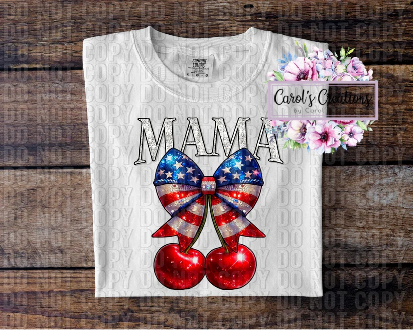 White t-shirt with American flag bow and cherries design on a wooden surface.