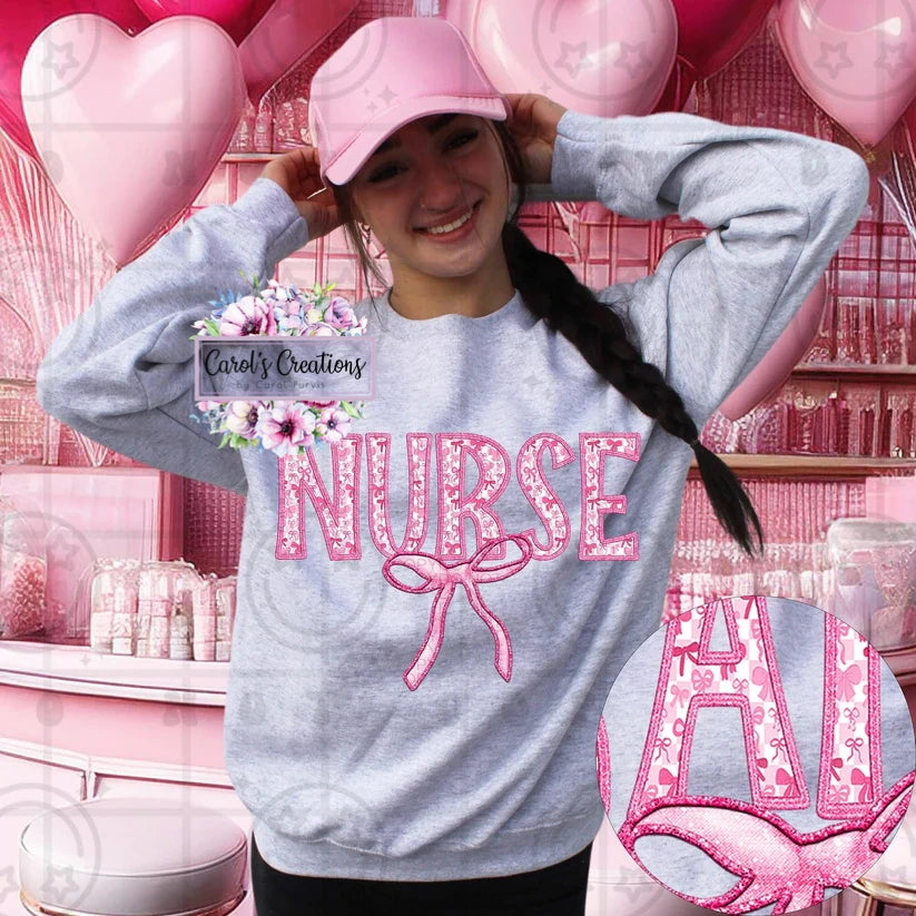 Person wearing a gray sweatshirt with 'NURSE' in pink letters, standing in a pink-themed room with balloons.