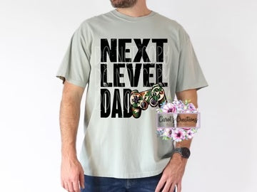 Person wearing a t-shirt with 'Next Level Dad' text and a butterfly graphic, standing against a white background.