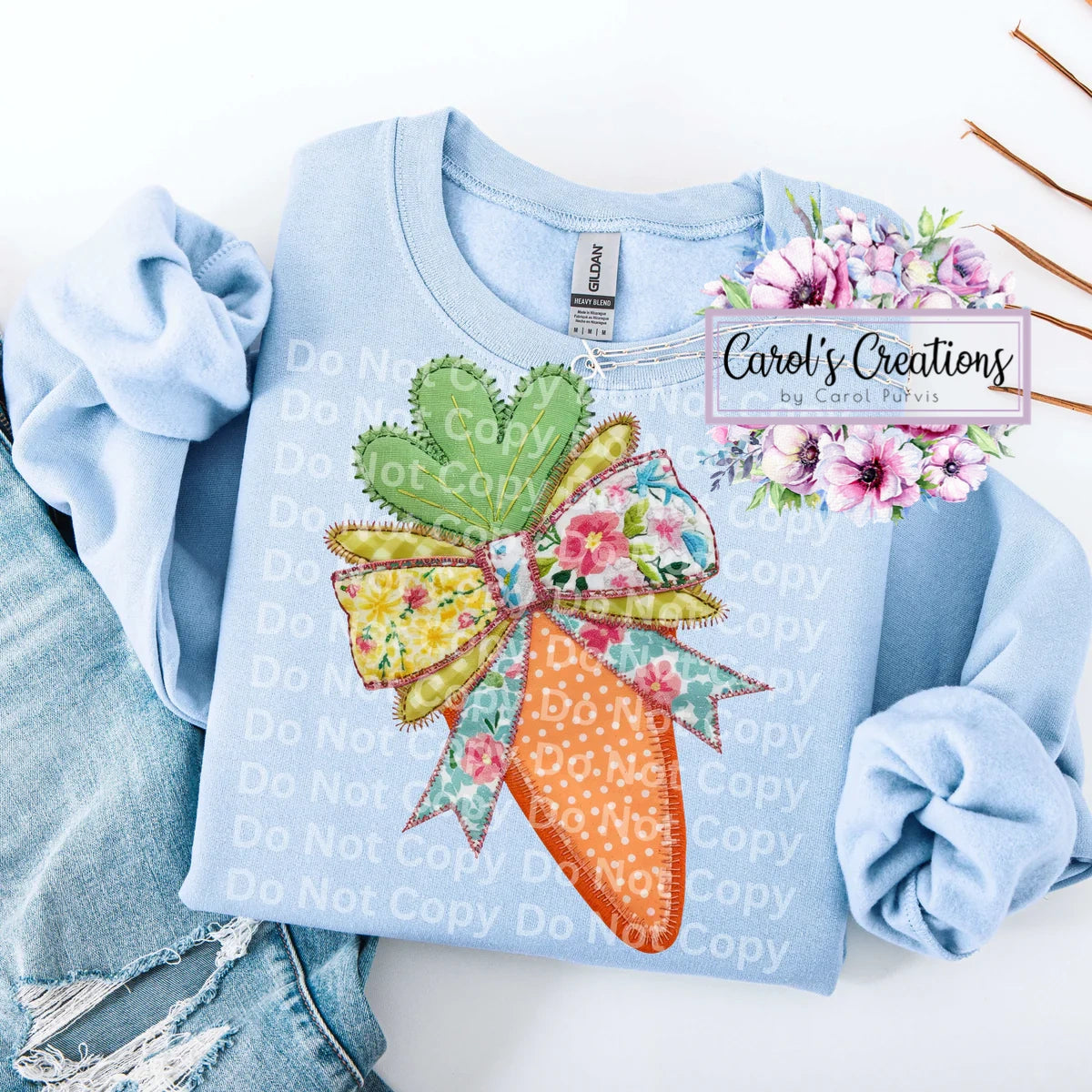 Light blue sweatshirt with a colorful bow and carrot design, branded 'Carol's Creations'.