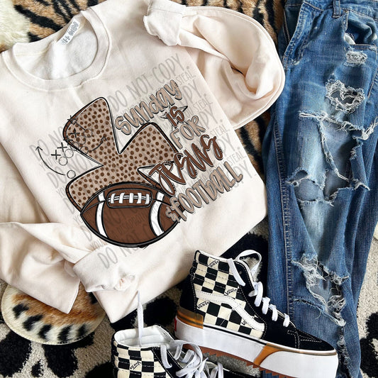 White sweatshirt with football graphic, jeans, and checkered sneakers on a patterned surface
