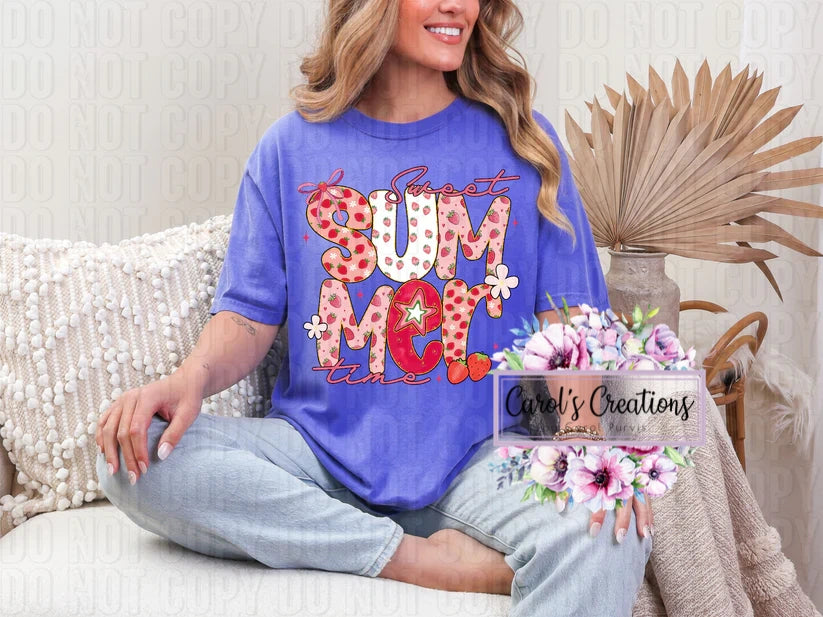 Woman wearing a blue t-shirt with colorful text, sitting on a couch with a decorative plant.