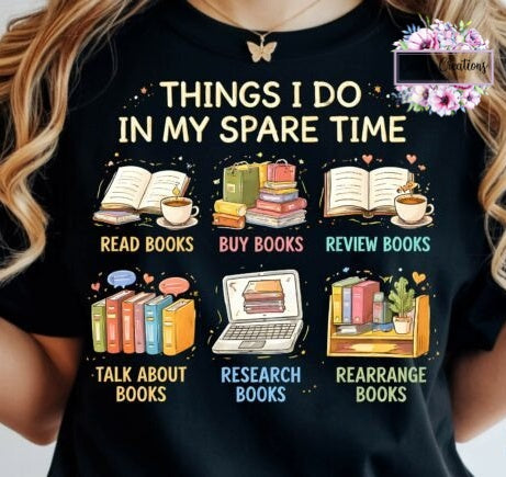 A woman wearing a black graphic t-shirt with a colorful print that reads 'THINGS I DO IN MY SPARE TIME' and lists activities like reading, buying, reviewing, talking about, researching, and rearranging books. The t-shirt has a 'creations' watermark in the top right corner.
