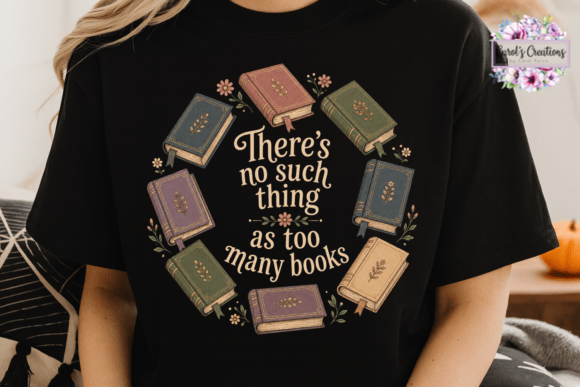 A person wearing a black graphic T-shirt with an illustrated circle of vintage books and the quote 'There's no such thing as too many books' in cream lettering. The photo is cropped from the shoulders to the waist, with a cozy indoor background and a small 'Lori's Creations' watermark in the upper right.