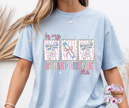 Light blue t-shirt with colorful text and graphics, worn by a person.