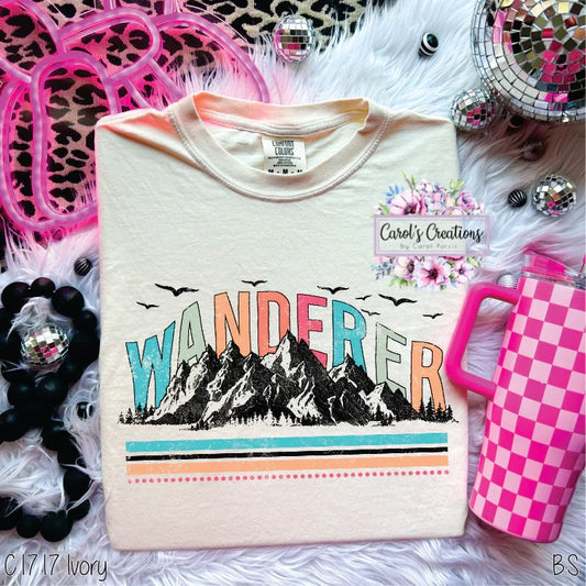 T-shirt with 'WANDER' design on a decorative background with accessories