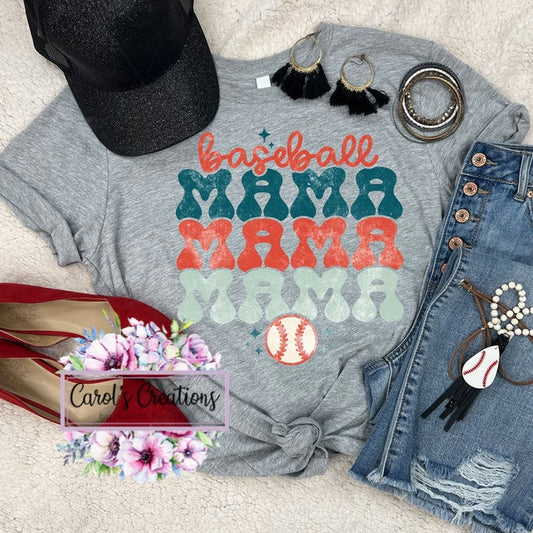 Gray t-shirt with 'baseball mama' text, black cap, denim shorts, and accessories on a light background.
