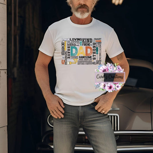 Man wearing a white t-shirt with colorful text design, standing in front of a car.