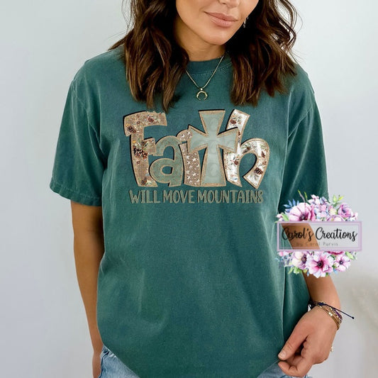 Person wearing a teal t-shirt with 'Faith Will Move Mountains' text, standing against a plain background.