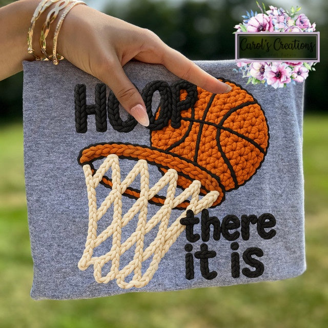 Hand holding a gray pouch with a basketball design and text 'HOOP there it is'.