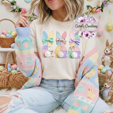 Person wearing a cream sweater with Easter-themed design, surrounded by Easter decorations.