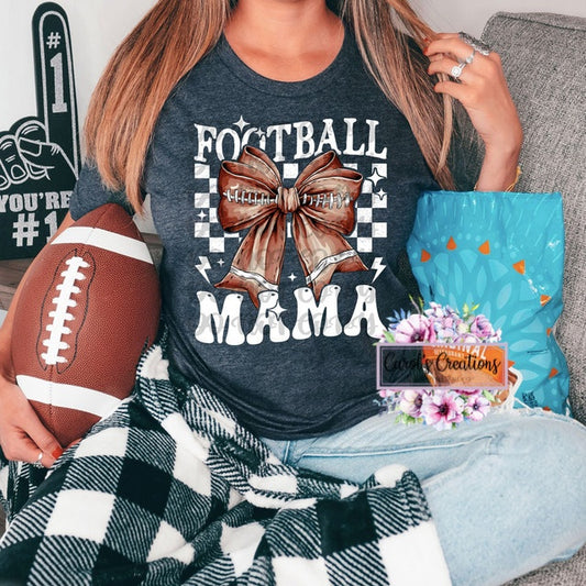 Person wearing a 'Football Mama' shirt holding a football, surrounded by decorative items.