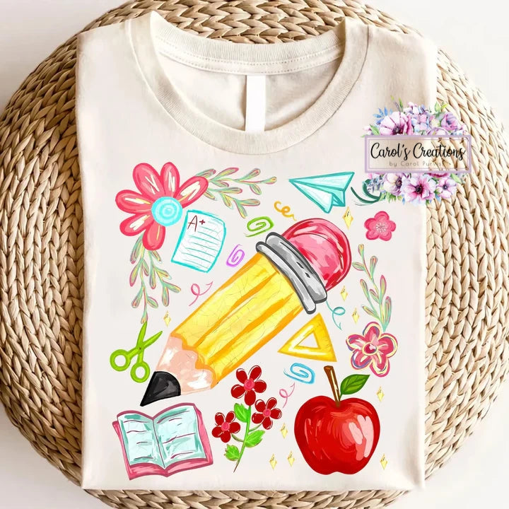 White t-shirt with colorful school-themed design on a woven surface