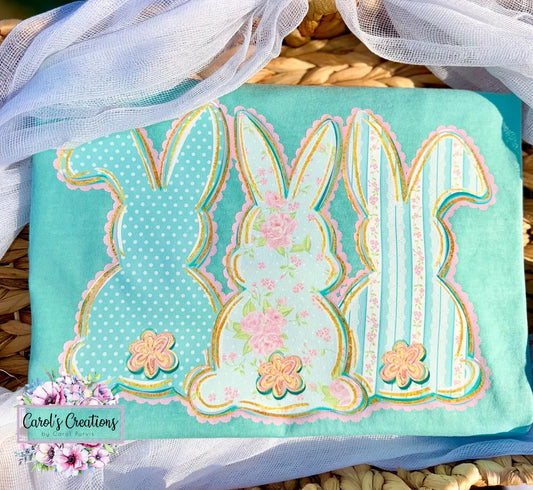 Fabric with bunny designs on a teal background, featuring floral elements, on a woven surface.