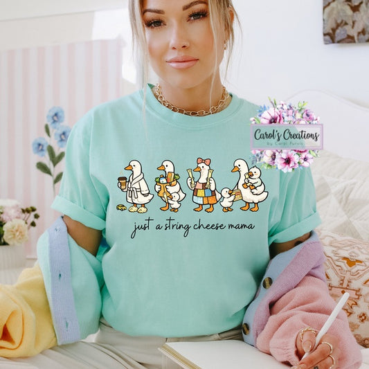 Woman wearing a light blue sweatshirt with cartoon ducks and text, sitting on a couch.