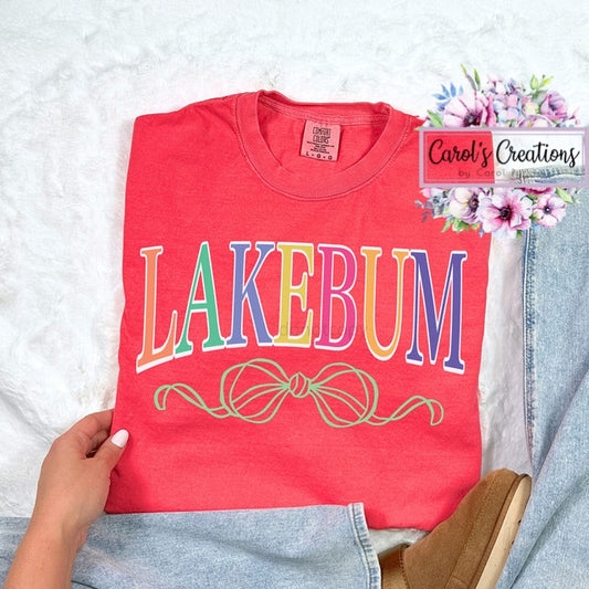 Red t-shirt with 'LAKEBUM' text held by a person on a light background