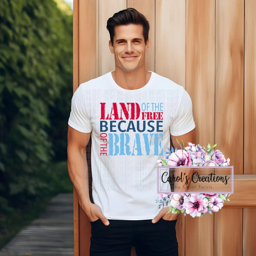 Man wearing a white t-shirt with colorful text, standing outdoors against a wooden wall.