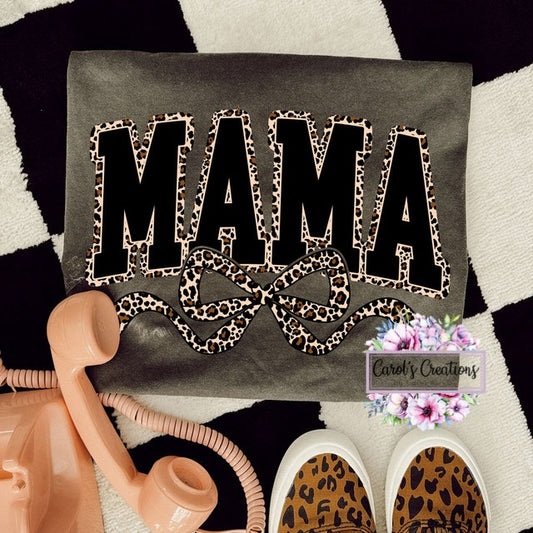 Decorative pillow with 'MAMA' and bow design on a checkered background