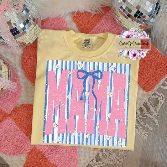 Yellow t-shirt with 'MAMA' print on a textured surface with disco balls and flowers.