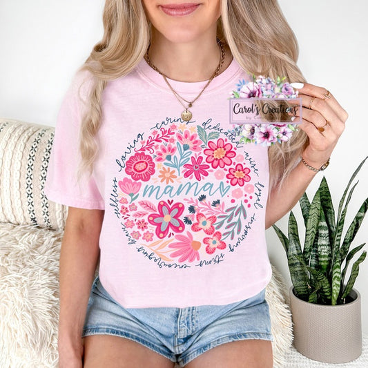Person wearing a pink t-shirt with floral design and text, holding a card with 'Carol's Creations' branding.