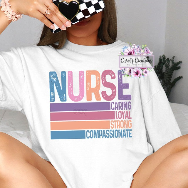 Person wearing a white t-shirt with colorful text 'NURSE' and attributes, sitting on a bed.