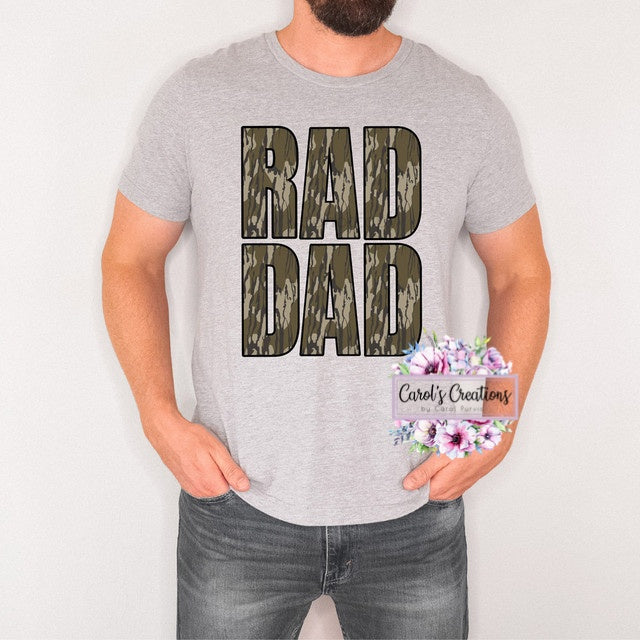 Person wearing a gray t-shirt with 'BAD DAD' text, holding flowers, on a plain background.