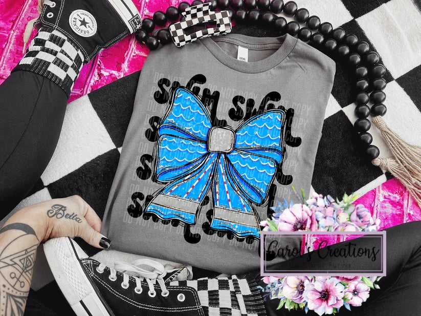 Gray sweatshirt with a blue bow design held by a hand on a checkered background.