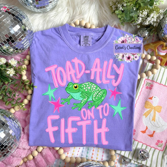 Purple t-shirt with a frog graphic and text on a decorative background