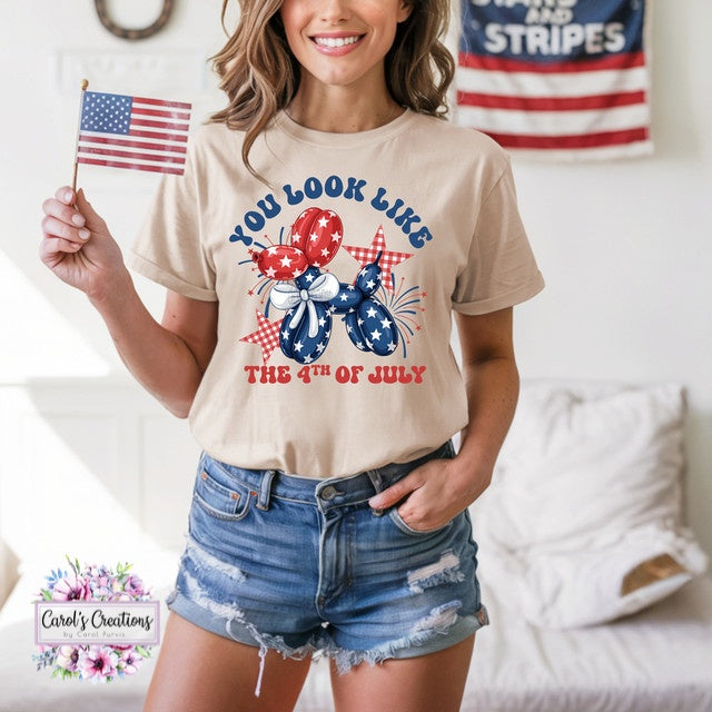 Woman wearing a t-shirt with a 4th of July design, holding an American flag, in a casual setting.