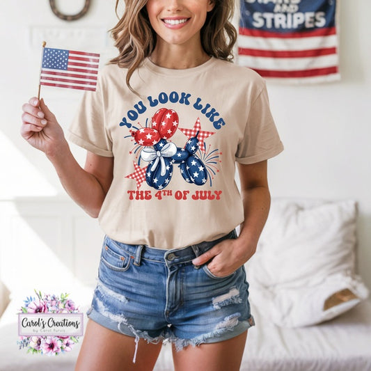 Woman wearing a t-shirt with a 4th of July design, holding an American flag, in a casual setting.